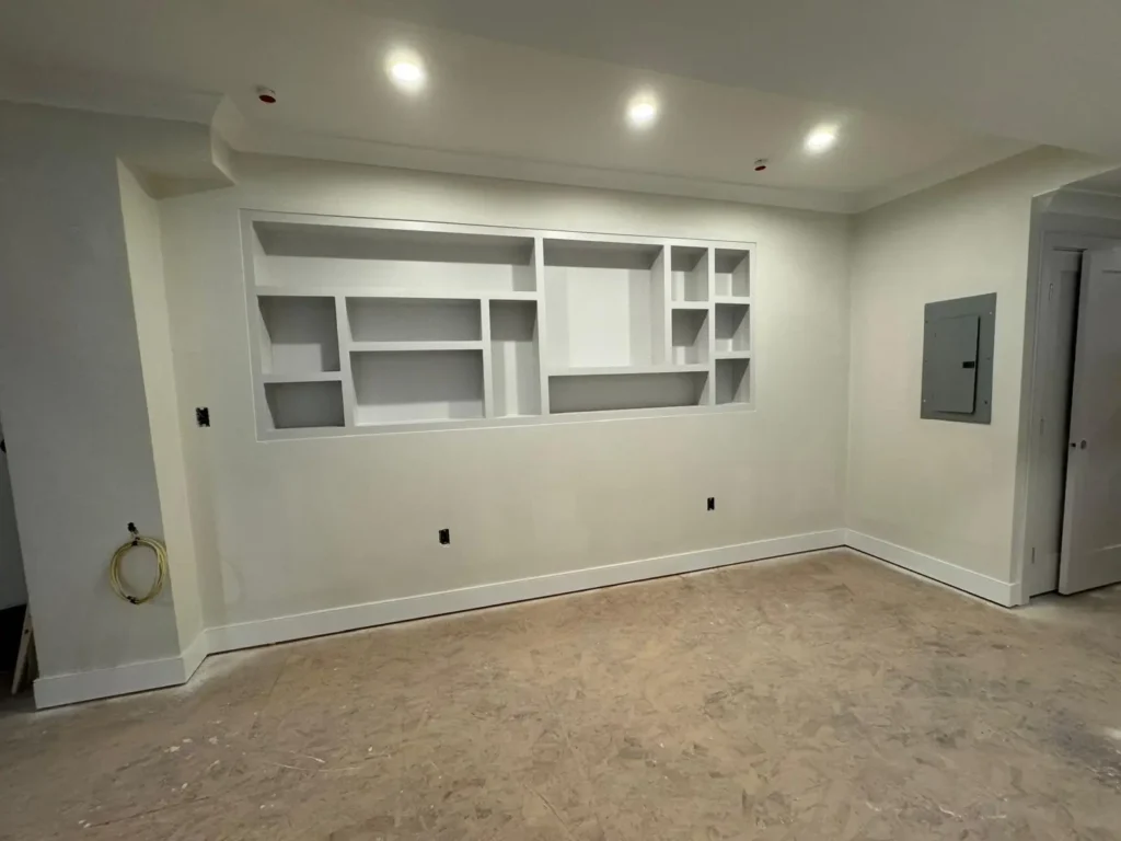 Built-in wall shelving niche with new baseboards