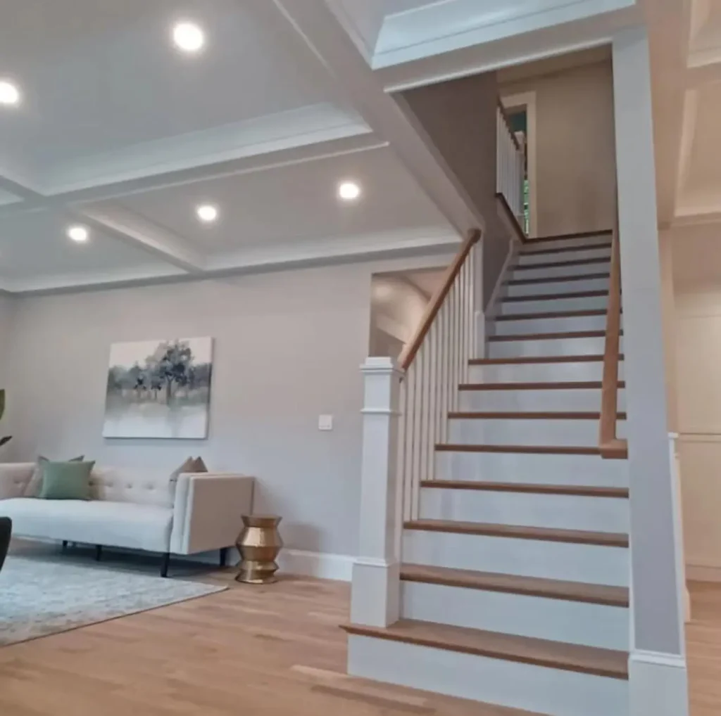 Living room with coffered ceiling and finished staircase